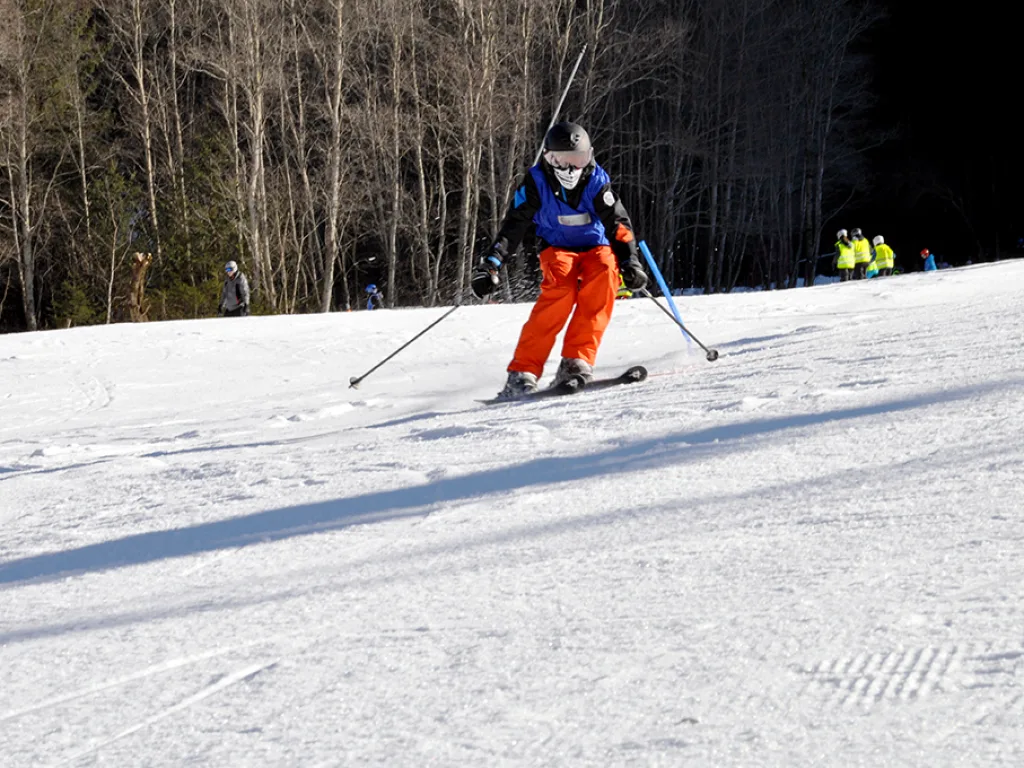 Skifahrer in oranger Hose auf der Piste.